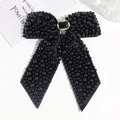 Close-up of black fabric bow hair clip with faux pearls and rhinestone center detail - Black