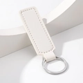 Minimalist white rectangular PU leather keychain with silver metal ring on stone pedestal - Rectangle / White