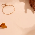 Elegante cavigliera in oro rosa con perle e catena a serpente su sfondo beige morbido - Bracciale in Oro Rosa a Strato Singolo con Catena a Serpente e Perline (M705)
