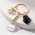 Portachiavi dorato con gatto bianco, perla con strass e ciondolo con nappa nera - Gatto bianco