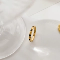 Detailed view of a slim gold ring with black enamel heart accents on a white background - Arc Black Zirconia