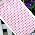 Close-up of pink 3mm round acrylic rhinestone stickers on a white adhesive sheet - 6mm / Pink