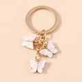 Golden keychain featuring three white butterfly charms with a polished metallic finish - Pearlescent White (YZ172baise)