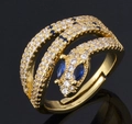 Gold snake ring with colorful zircon stones and blue gems on black background - Snake with Blue Eyes