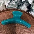 Elegant large peacock blue bow hair claw clip made of glossy acrylic on a wooden display - French Style Claw