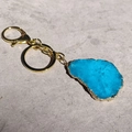 Detalle del llavero de ágata azul irregular con borde de metal dorado y cierre de mosquetón - Tamaño Irregular / Aguamarina