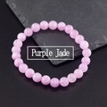 Elastic beaded bracelet with round purple jade gemstones on a dark rock background - Purple Jade Style