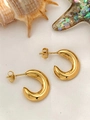 Detail view of chunky golden C-shaped hoop earrings on beach theme decorative background - Chunky C-Shape Earrings