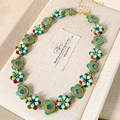 Dettaglio collana floreale vintage con gemme colorate e smalto verde in una scatola - Collana di Fiori (Collana-Oro-Verde)