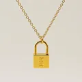 Macro view of gold padlock pendant featuring engraved letter F on a polished surface - Letter E Style