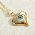 Macro view of gold heart pendant with green devil eye detail and delicate gold chain - Green Heart (XL2710-2)