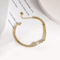 Detalle de pulsera de clip dorada con dije de ojo de circonita y diseño de alfiler - Ojo Turco Púrpura Pálido (C)