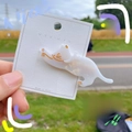 Detailed view of a cute white cat-shaped acrylic hair clip on a paper display card - White Mermaid