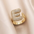 Adjustable gold plated ring featuring letter E encrusted with clear cubic zirconia stones - Small / Letter E