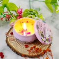 Pink unicorn tin scented candle with yellow wax and dried flower petals burning on wood - D33 Paris Reverie