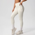 Close-up of high-waist yoga leggings with side pocket holding a mobile phone - S / Bottoms / Light Ivory