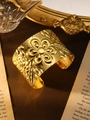 Detail eines böhmischen Goldarmbands mit Vintage-Blumenmuster auf Samthintergrund - Gravierte Blume Gold