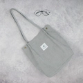 Light grey corduroy tote bag with dual shoulder straps and minimalist graphic patch - Gray