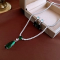 Detalle del collar con colgante de gota de esmeralda vintage y pendientes de botón a juego - Verde