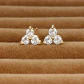 Macro view of gold clover stud earrings with sparkling round cubic zirconia stones - Gold/White Zirconia