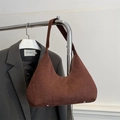 Detalle del bolso bajo el brazo de ante marrón con diseño minimalista y remaches metálicos - Marrón