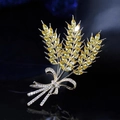 Macro shot of a golden wheat stalk brooch with yellow crystals and a ribbon bow detail - Wheat Ear Style (X0145)