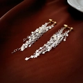 Close-up of long tassel earrings with silver sequin chains on brown silk fabric - Gold and Silver Chain Tassel Earrings (HE15702)