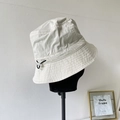 Detail of adjustable drawstring and reinforced stitching on cream nylon bucket hat - Beige