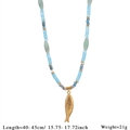 Detailed macro view of the golden fish pendant on a blue and green natural stone necklace - Gold Fish Pendant Style (Style 2)