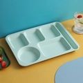 Hellblaue Weizenstroh-Bento-Platte mit fünf Fächern auf farbenfrohem Hintergrund - Einzelner Geteilter Teller / Grün