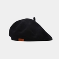 Detail of black knit beret showing hollow weave texture and brown leather logo tag - M (56-58cm) / Black
