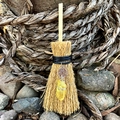 Macro view of a mini wicca broom pendant with a silver pentagram and yellow crystal stone - Pentagram with Yellow Crystal