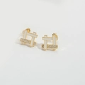 Close-up of lightning bolt earrings with gold frames, white enamel, and zircon accents - Square Studs / White Round