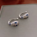 Close-up of silver snake ear clips with blue marquise zircon eyes and white diamonds - Silver