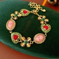 Detalle de pulsera dorada vintage con gemas de corazón rojas y camafeos rosa en terciopelo - Pulsera (Dorado-Verde)