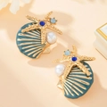 Golden starfish stud earrings with blue rhinestones and white pearl on peach backdrop - Stud Earrings