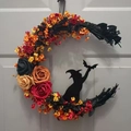 Detail of crescent moon wreath with black branches, roses, and a wizard silhouette on a door - Four-Color Foam Flower Moon