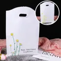 White plastic gift bag with yellow daisy print and cut-out handles for cosmetics - 20x27cm / Daisy