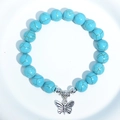 Blue turquoise bead bracelet featuring a silver metal butterfly charm on white background - Blue Turquoise Large Butterfly Charm