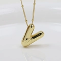 Macro shot of 3D puffy gold letter V pendant with polished metallic luster and texture - Letter V (Necklace)