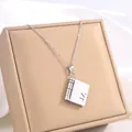 Macro view of book-shaped titanium steel pendant with hollow heart on silver chain - 73 Silver Customizable Necklace