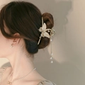 Detail view of a gold flower hair claw with pearl butterfly design and long tassels - Yellow Tassel Butterfly