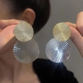 Close-up of gold and silver layered round earrings with spiral texture on metal surface - Spiral Double Circle / Silver