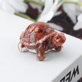 Carved reddish-brown natural stone turtle figurine with dark veins on a white book - 71 Red Jasper