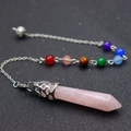 Close-up of pink hexagonal crystal pendulum necklace with silver filigree and beads - Rose Quartz