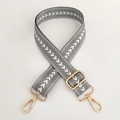 Close-up of grey nylon crossbody strap with white arrow pattern and gold metal hardware - Grey With Silver Buckle
