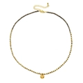 Detail of bohemian gold beaded necklace with a hand-hammered round pendant and 18K finish - Coffee