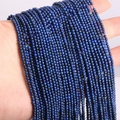 Macro shot of 2mm dark blue natural stone lapis lazuli beads held by hand for DIY jewelry - Lapis Lazuli