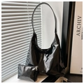 Set borsa tote in pelle verniciata nera lucida con pochette coordinata sotto luce naturale - Nero