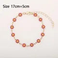 Golden daisy chain bracelet featuring twelve red and yellow floral charms with lobster clasp - Red Daisy (Gold Tone)